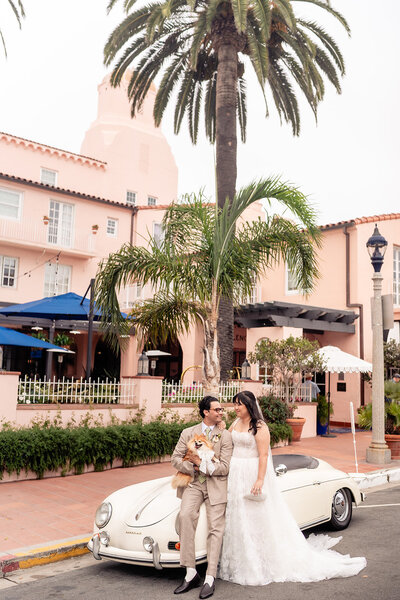Bride and Groom standing on staircase with long dress at La Valencia wedding venue