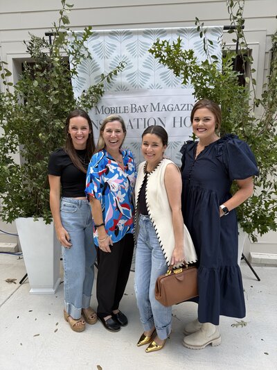 photo of kelly francis and three members from the loyola art show team at the inspiration home opening for mobile bay magazine