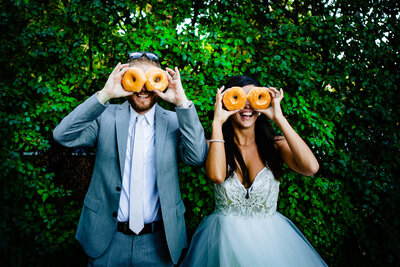 Wedding couple laughing and holding donuts over their eyes as it shows we are Curated To You, "There is a common thread in Loren + Mary Beth's work, but every wedding I see is entirely unique to each couple and is absolutely breathtaking".
This quote says it all.