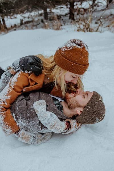 couples rolling around in the snow