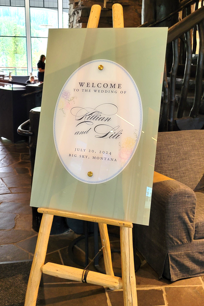 Double-layer acrylic welcome sign for a Moonlight Basin wedding, designed with a floral theme in soft pastel tones to complement the day-of stationery and mountain setting.