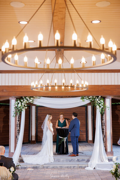 Breathtaking floral archway with blush pink and ivory flowers by Leigh Florist, creating a dreamy entrance for a wedding ceremony.