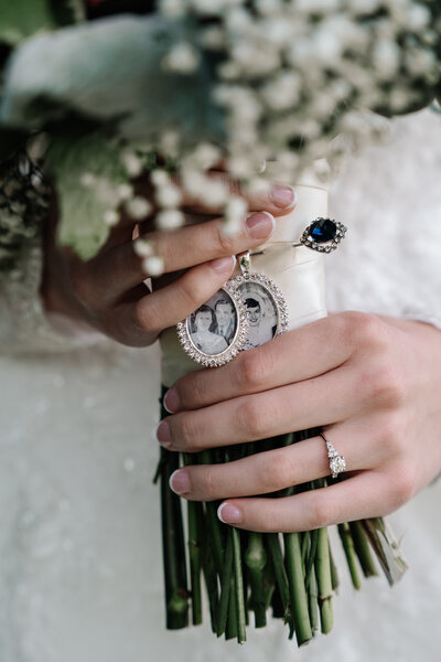 Bride holding bouquet with locket of lost loved ones