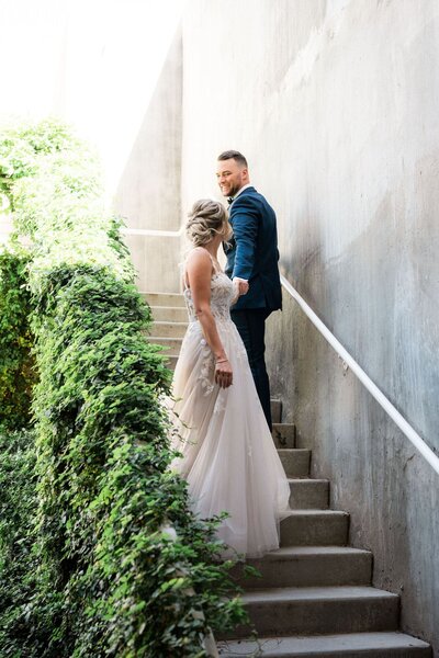 Bride and groom walking down the stairs in the garage at Mountain Shadows
