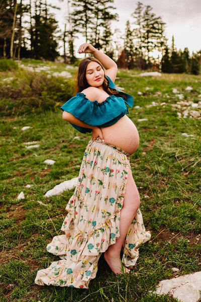 Captured by a family photographer in Albuquerque, this heartwarming image features a mom holding her beautiful baby dressed in a red outfit. The mom is stunning in a vintage orange dress, creating a timeless and vibrant family portrait.