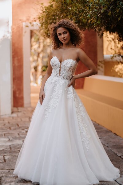 Angular paneling and intricate lace cover the overlay of this sheath gown.