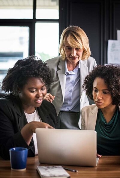 three diverse women looking at a computer