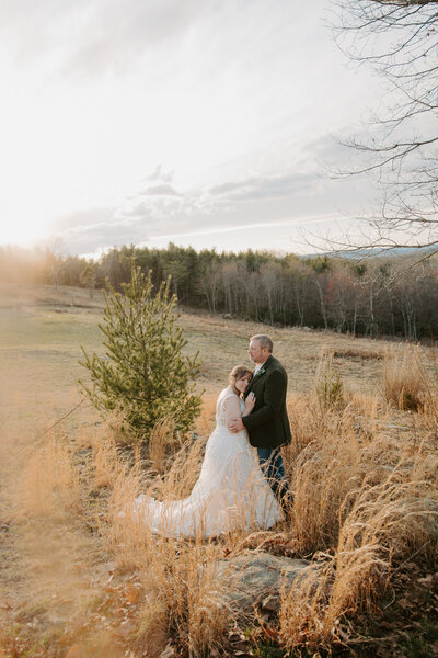 bride and groom holding each other as the sun sets behind them on the parkway while eloping in Virginia