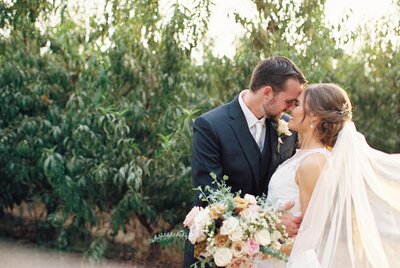 bride and groom almost kissing wedding veil sweeps in front