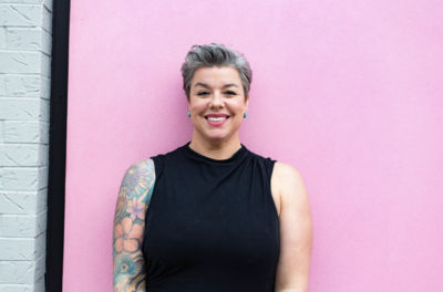 Chicago counselor standing against a pink wall while smiling