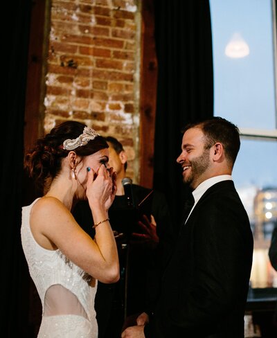 Bride wipes away tears during her wedding ceremony