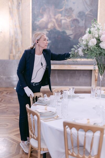 ECLAT Destination Wedding Planner adjusting flowers at the luxury dining table in Hotel Imperial Vienna