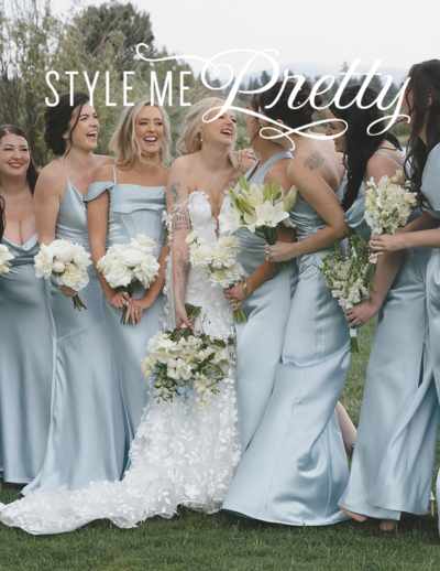 Bride laughing with her bridesmaids, sharing a joyful and candid moment together on the wedding day.