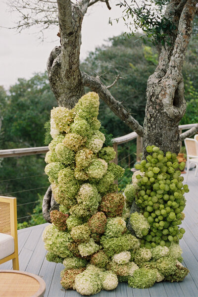 Flowers wrapped around a tree on the deck at a beach house for the wedding day at the coast of NC