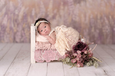 Newborn photoshoot holding cute little pink flowers