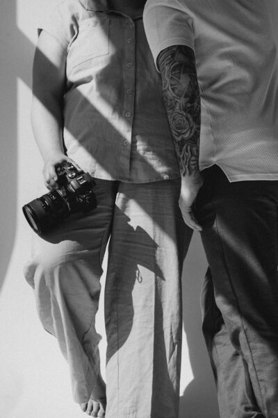 A close up of two people standing together while one holds a camera