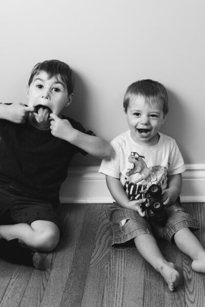 two brothers sitting on the floor making funny faces