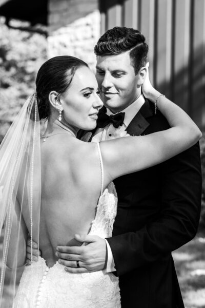 Bride and groom embracing with bouquet