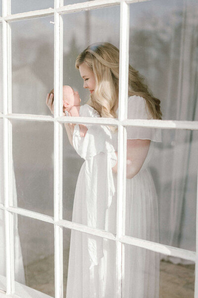 Cozy living room Bay Area newborn photography session with baby wrapped in a blanket.