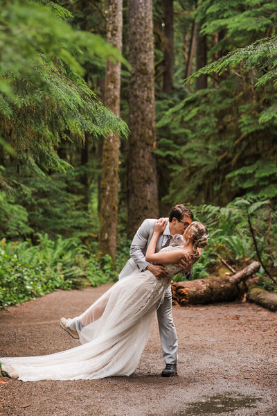groom dips a bride in the deep forest of Olympic National Park