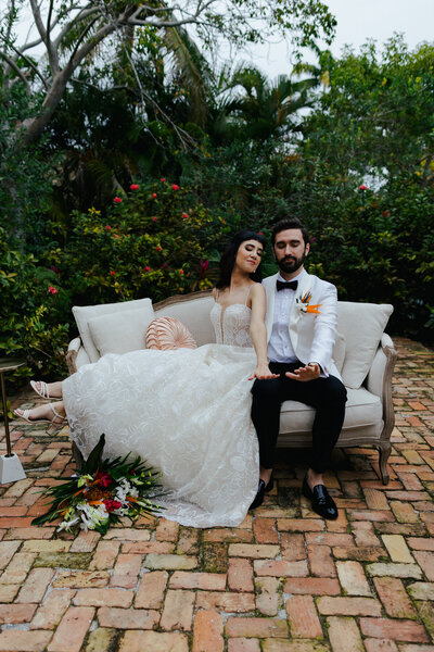 Quirky Bride and Groom posing on living room furniture at their Massachusetts Wedding