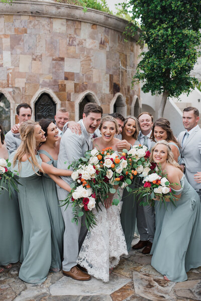 Wedding party celebrates with a group hug at  destination wedding in Mexico