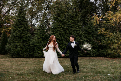 A wedding couple snuggles in the sunset while the bride holds her dress