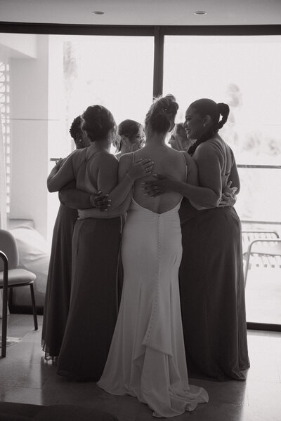 candid group hug with the girls after first look
