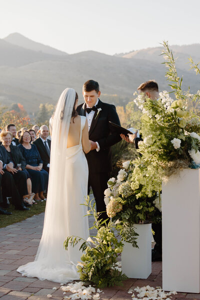 bride and groom at alter with mountains in the distance at the manor house in littleton colorado