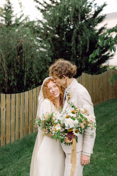 Bride and groom posing together in a lush backyard setting in Richmond.