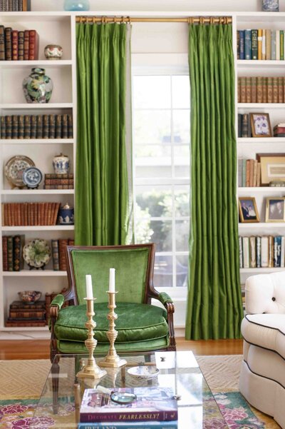 interior home with green curtains and bookshelf