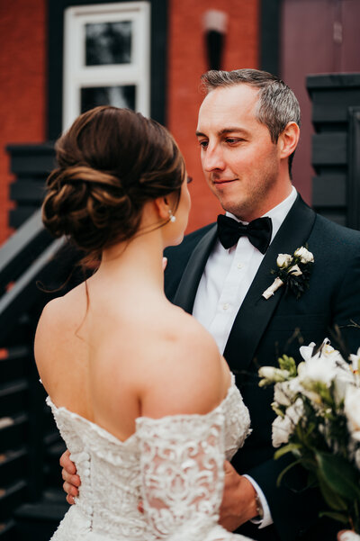 Groom looking at bride outside of Studio 96 wedding venue in Edmonton, Alberta