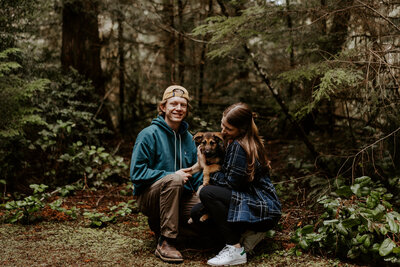 Hannah, Adam, and Juneau posing together in front of the forest