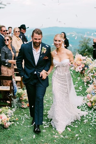 Bride and groom smile as they walk back down the aisle after taking their vows