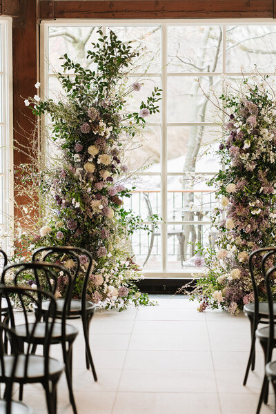 Floral ceremony arch inside Central Park Boathouse in New York City — editorial wedding photography capturing atmosphere and design details.