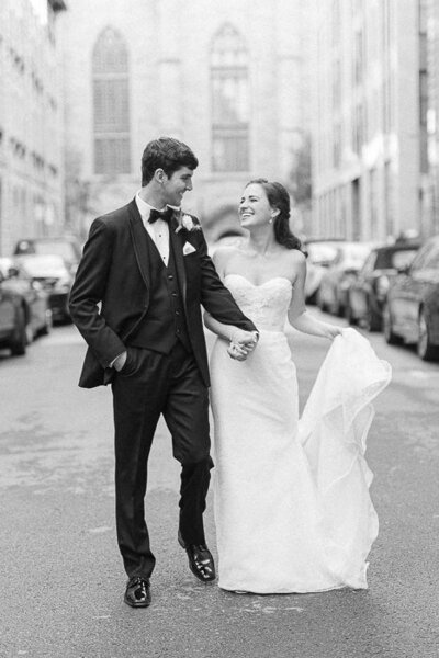 Un couple de nouveaux mariés, souriant, marchant dans une rue du Vieux Montréal.