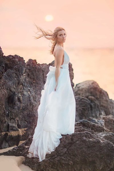bride poses on lava rock for maui wedding portraits by love and water