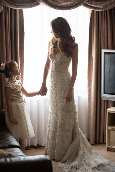 bride looking at little girl in fornt of window