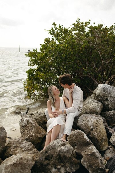 Romantic beach engagement photos with rocks at Cypress Point Park in Tampa FL