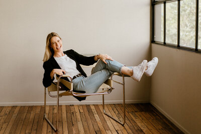 Brisbane Photographer Hannah Redman reclines in a chair and smiles at the camera