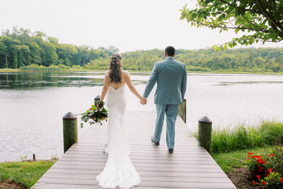 Couple walking on lake dock for portraits