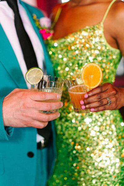 Two people holding cocktails.