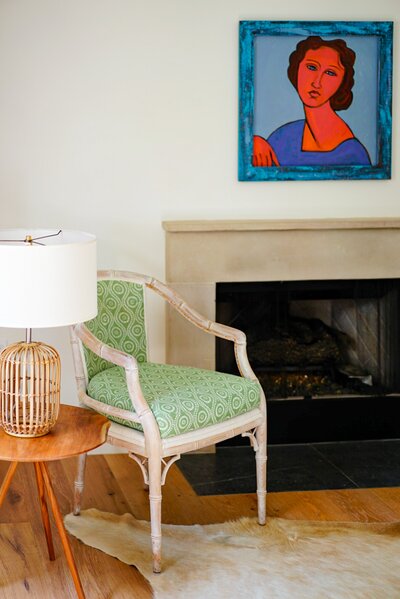green chair by a fireplace with boho lamp