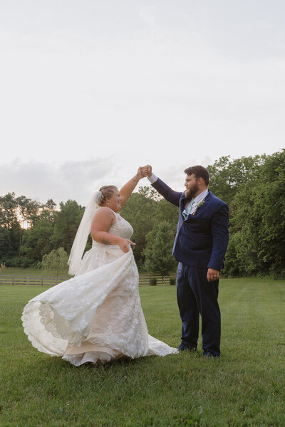 Wedding photo of a groom twirling his bride in a field at sunset in Afton, TN. Northeast, TN lifestyle wedding photographer. 