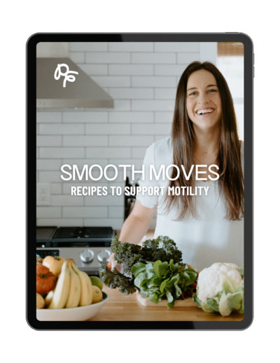 Woman smiling in a kitchen with bowls of fruits and vegetables on the counter