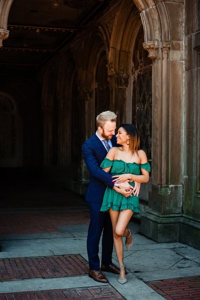 Engagement Session in Central Park in New York City with bride in short green dress and groom wearing a navy suit