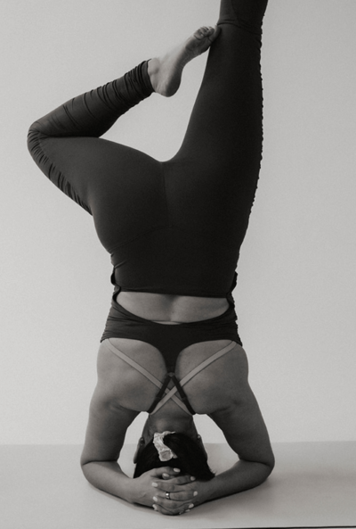 Woman fitness instructor doing a headstand.