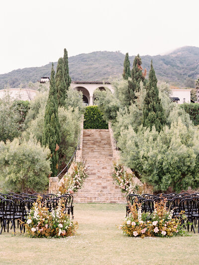 Wedding ceremony location with black chairs and floral-lined aisle at Klentner Ranch wedding venue