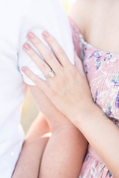 bride lays hand on groom's arm showing off her engagement ring