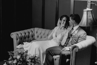 Bride and groom sit on a couch